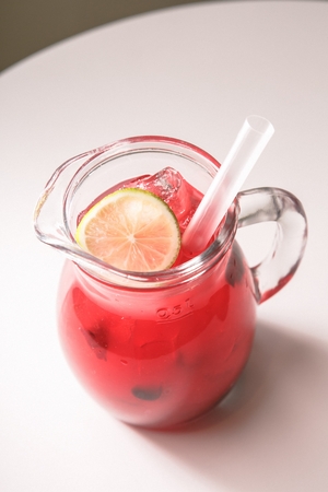 Iced blueberry ade with lemon slices in glass, with strawの写真素材