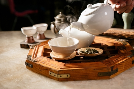 Traditional kettle and teacup containing hot teaの写真素材