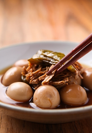 Beef boiled down in soy sauce with quail eggs, on china plate