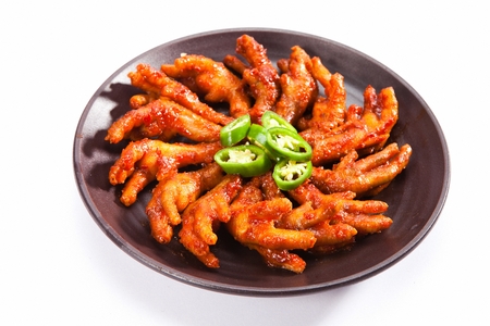 Spicy chicken feet with chili on china plateの写真素材