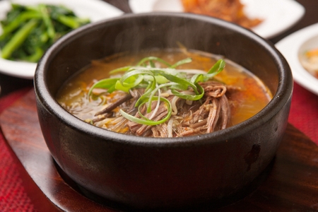 Rice soup with beef, in pot with side dishesの写真素材