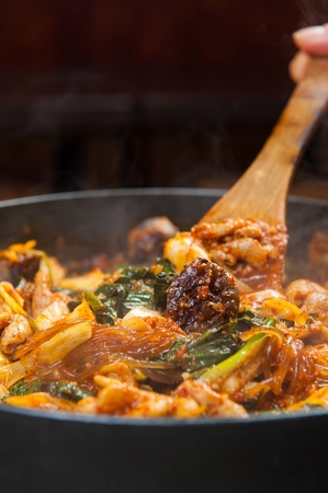 Stir-fried tripes and korean sausages being grilled on iron plateの写真素材