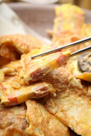 Chopstick grabbing assortment Korean pancakes served on plateの写真素材