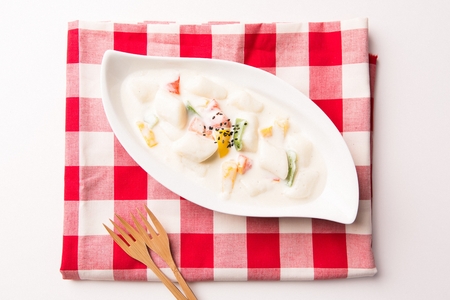 Carbonara spicy rice cake with paprika inside served in bowl with forkの写真素材