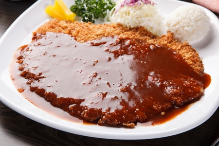 Pork Cutlet with Sauce and Salad Served on Plateの写真素材