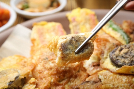 Assortment Korean pancakes served on plate with chopsticksの写真素材