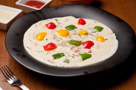 Carbonara spicy rice cake with paprika inside served in bowl with forkの写真素材