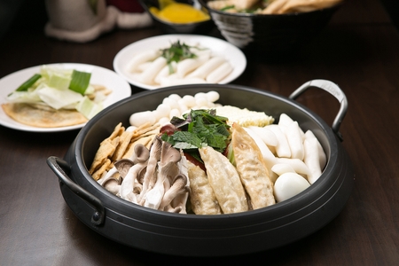 Spicy Rice Cake sauce with rice cake, fish cakes, mushrooms, and dumplings, served on panの写真素材