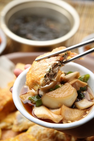 Chopstick grabbing assortment Korean pancakes with onion chili pepper sauce served on plateの写真素材