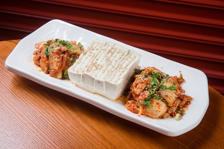 Tofu and Kimchi with sesame seeds on top served on plate