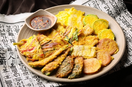 Assortment Korean pancakes with soy sauce served on plateの写真素材