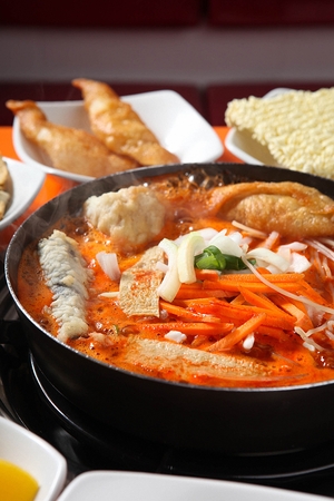 Spicy Rice Cake cooked on spot with fried vegetables on pan with spicy rice cake ingredients served on plateの写真素材
