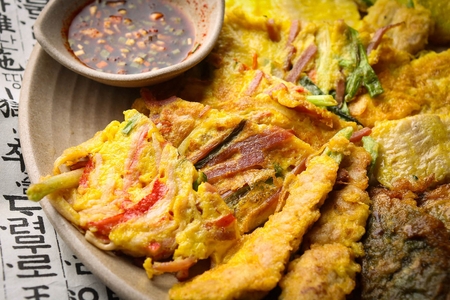 Assortment Korean pancakes with soy sauce served on plate