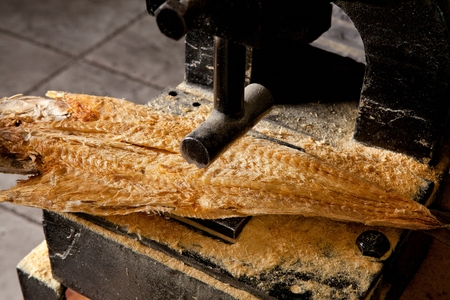 Thin sliced Dried Alask Pollack served on wooden machineryの写真素材
