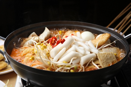 Spicy Rice Cake with beansprouts and chili peppers cooked on the spot served on panの写真素材