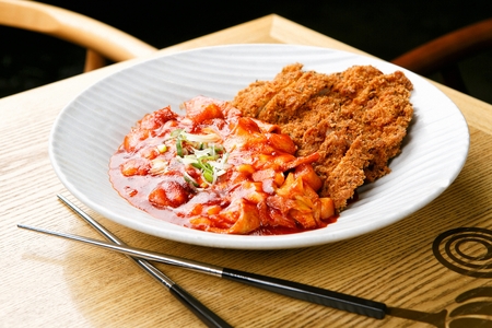 Spicy Rice Cake with spring onion, pork cutlet served in bowl with chopstickの写真素材