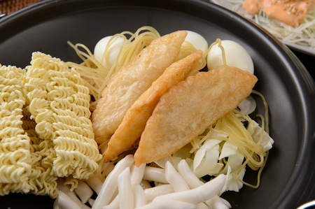 Spicy Rice Cake ingredients with noodles, fried dumplingss and eggs served on pan