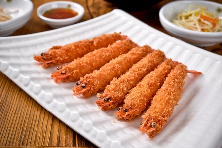 Fried shrimp with side dishes served on plate