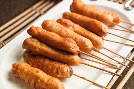 Hotdog served on plate on bamboo shootの写真素材