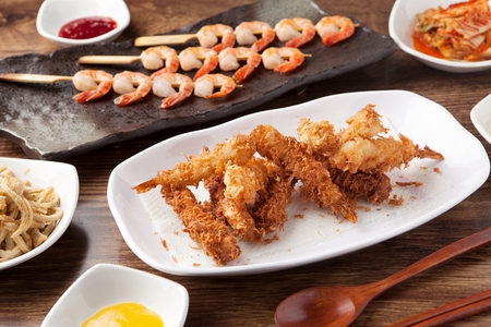 Fried shrimp with side dishes served on plate with chopsticksの写真素材