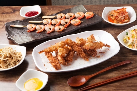 Fried shrimp with side dishes served on plate with chopsticksの写真素材