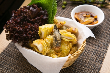 Fried Squid with perilla leave, cabbage and sauce served on bamboo plateの写真素材