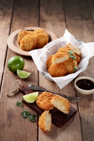 Potato Croquette with lime, and sauce served in wooden bowl with forkの写真素材