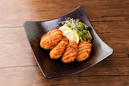 Curry Croquette with sauce served on bamboo plate with chopstickの写真素材