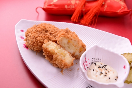 Potato Croquette with sauce and pickles served on porcelain plateの写真素材