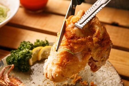Fried Squid with Scissors and tongs served on plateの写真素材