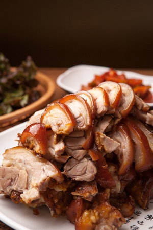 Pig feet with chives, lettuce, garlic, and Korean soybean paste served on plateの写真素材