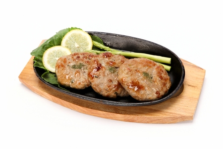 Grilled short rib patties with asparagus and lemon served on iron plate