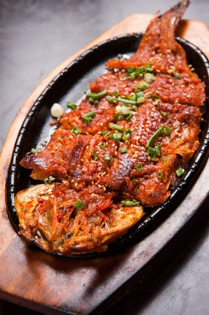 Grilled Red Pepper Paste Pollack served on wooden grill plateの写真素材