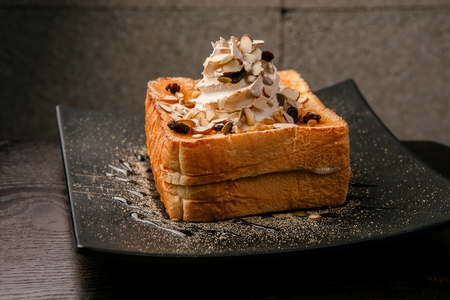 Honeybread with nuts and cream on top seerved on plate
