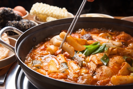 Spicy Rice Cake cooked on the spot served on pan with spicy rice cake ingredients served on plate with chopsticksの写真素材