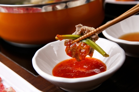 close-up shot of dipping Shabu-shabu beef in sauceの写真素材