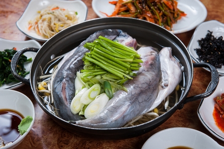 Korean cuisine Maeuntang, spicy fish stew with spring onion, garlic chives and white soup in potの写真素材
