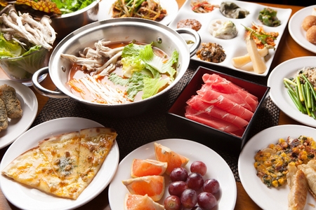 Shabu-shabu ingredients, spicy soup with mushroom, cabbage and vegetables served with beef and vegetables platter and various side dishの写真素材