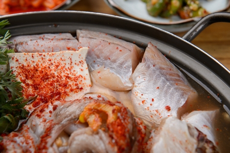 Korean cuisine Haemul-tang, spicy seafood stew with crown daisy, bean sprout, shrimp crab, fish and radish in potの写真素材
