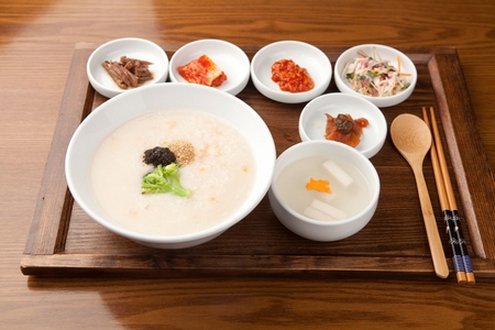 Mung bean rice porridge served with white kimchi cold soup and various side dishの写真素材