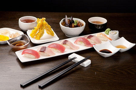 tuna sushi platter, a piece held in chopsticksの写真素材