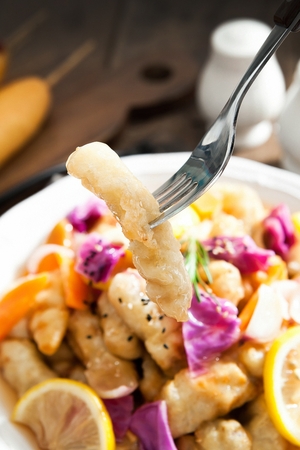 Tangsuyuk, Korean style sweet and sour pork with carrot, cabbage and sliced lemon in disposable plateの写真素材