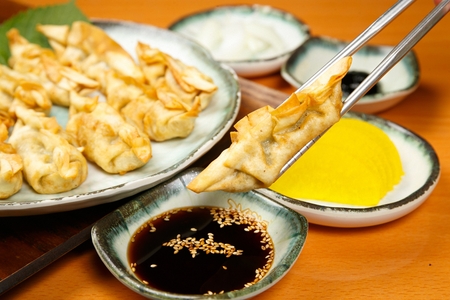 flat fried dumpling dipped in soy sauceの写真素材