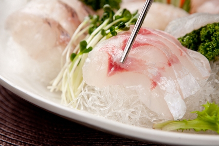 flatfish sashimi on chopsticksの写真素材
