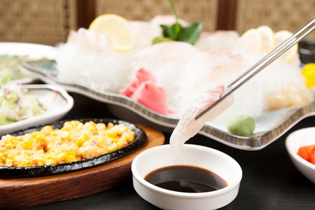 fish sashimi dipped in soy sauceの写真素材