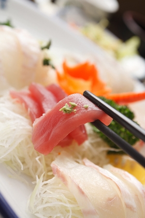 tuna sashimi with wasabi on chopsticksの写真素材