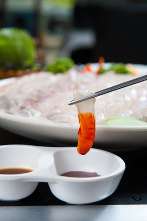 fish sashimi dipped in spicy chili sauceの写真素材