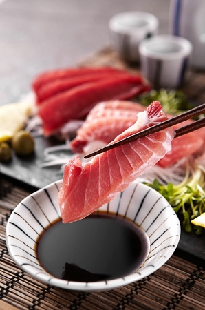 tuna sashimi dipped in soy sauceの写真素材