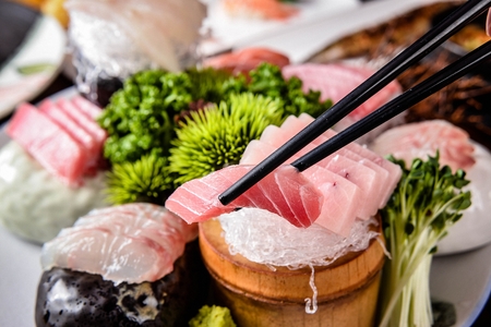 tuna sashimi on chopsticksの写真素材