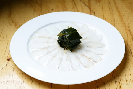flatfish sashimi and seaweed on plate